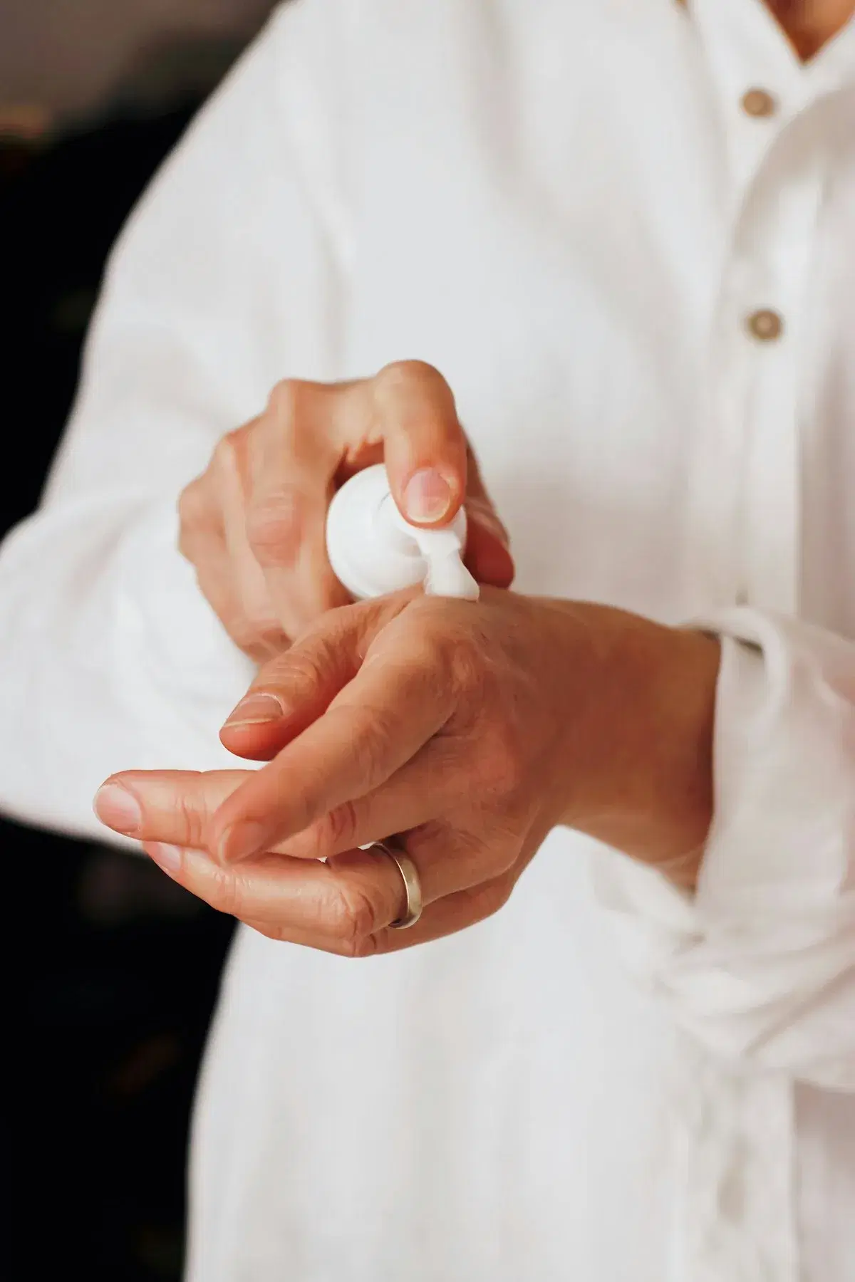 Hands applying an illustrative skin-care lotion